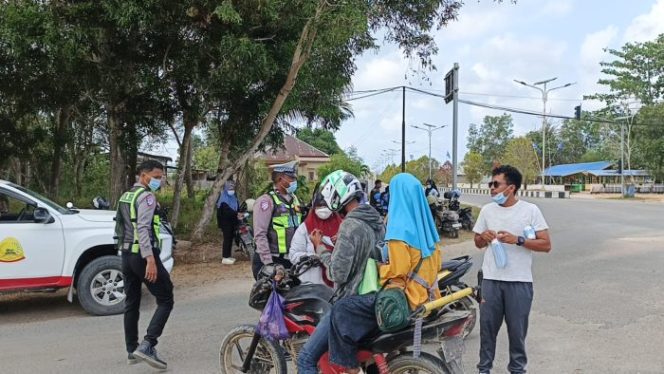 
					Foto : Satlantas Polres Taliabu saat membagi masker ke pengendara (dok.ist)